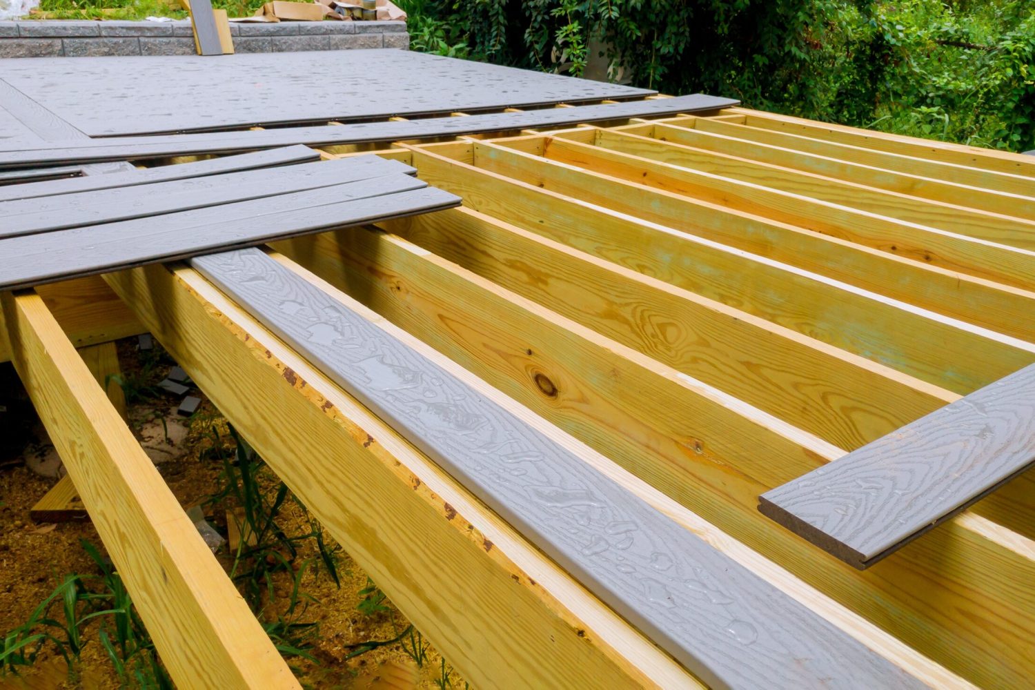 A new wooden, timber deck being constructed. it is on the decking. New deck patio