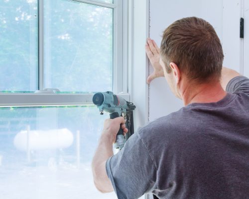 Worker installing trim around a window molding installed moldings materials